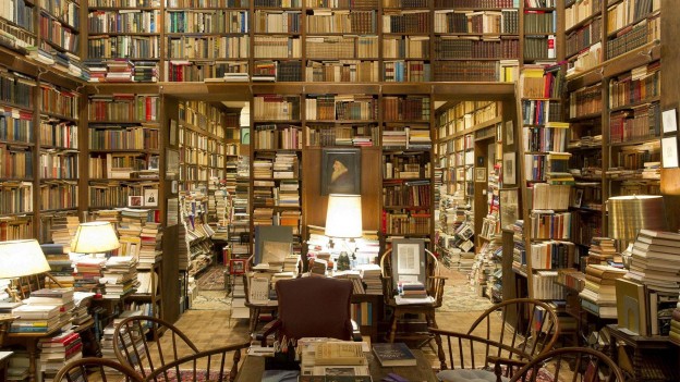 Piles of books in a private college library www.LuxuryWallpapers.net